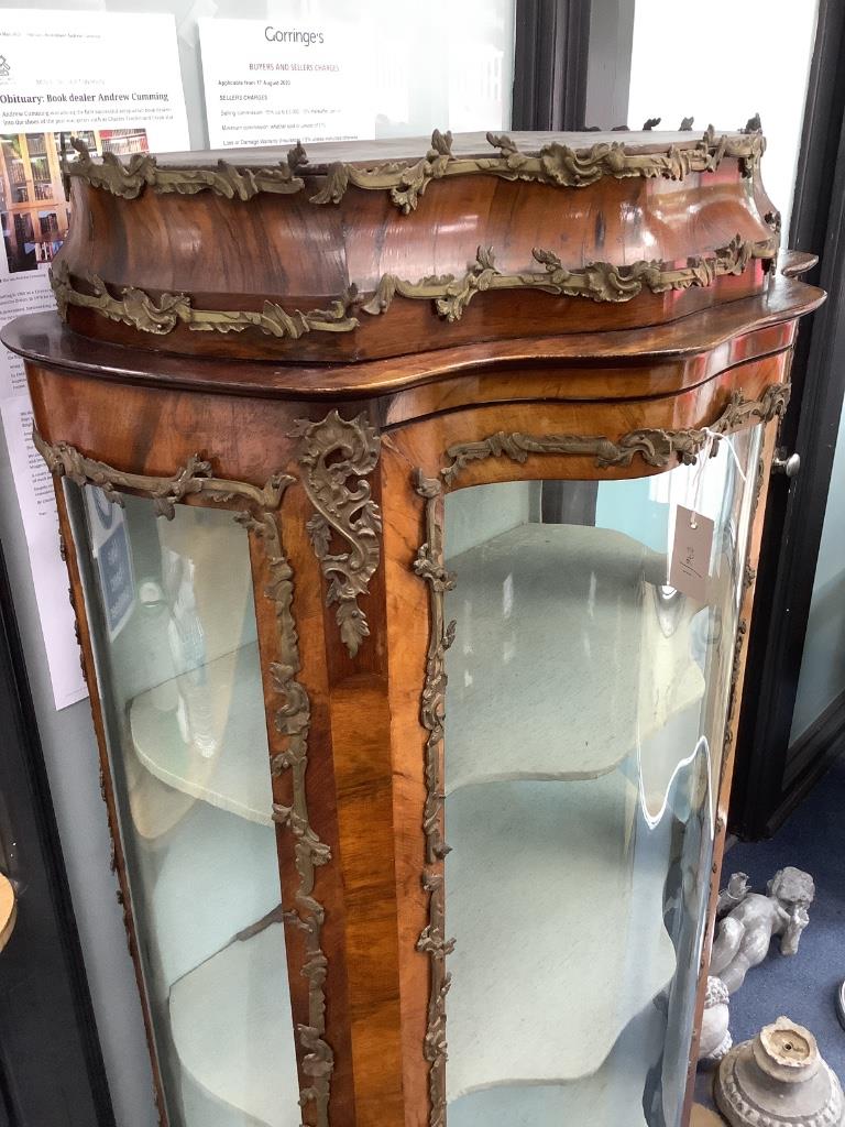 An early 20th century French gilt metal mounted rosewood vitrine, with central serpentine glazed door marquetry inlaid with flowers in a basket, on cabriole legs, width 74cm depth 48cm height 172cm